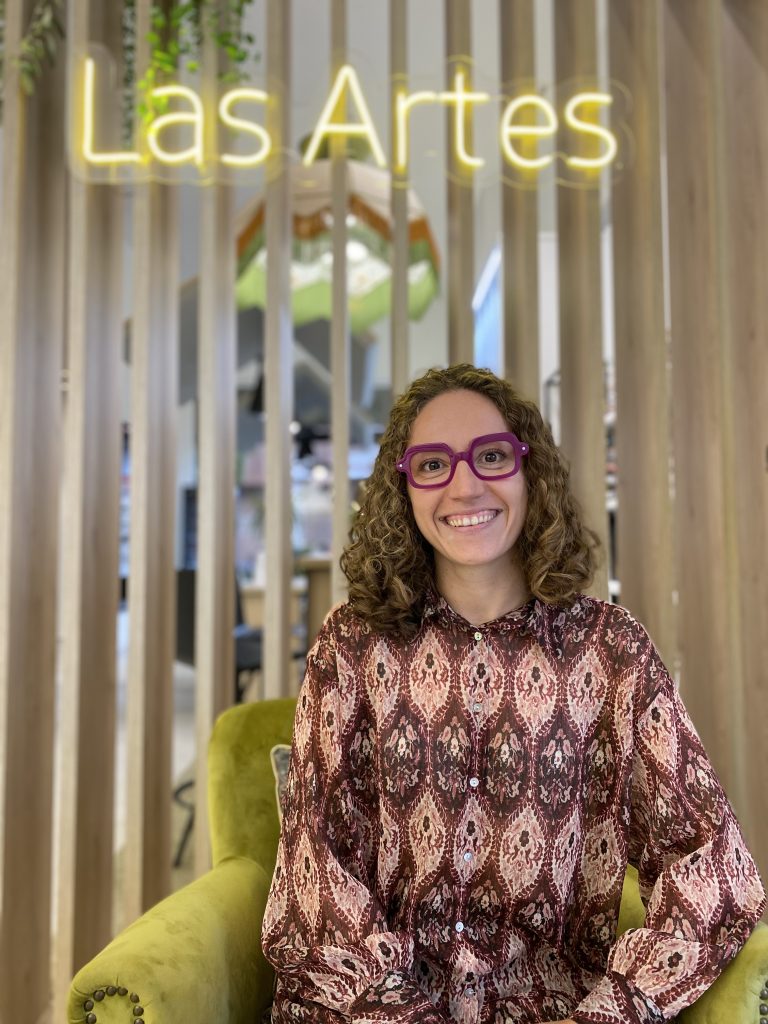 Nuria de centro óptico LAS ARTES con sus gafas rojas y rosas